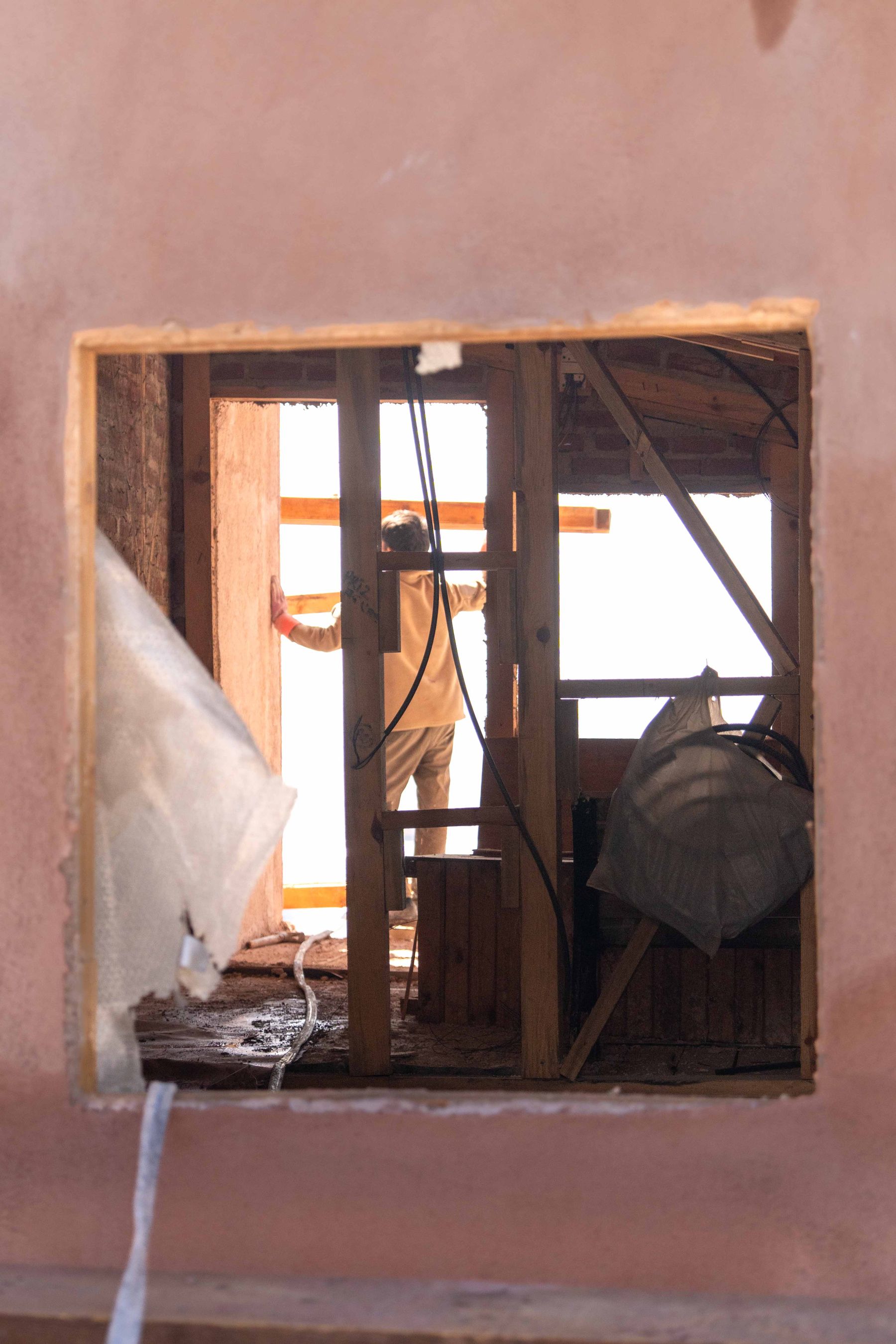 Interior renovation with worker and exposed framing
